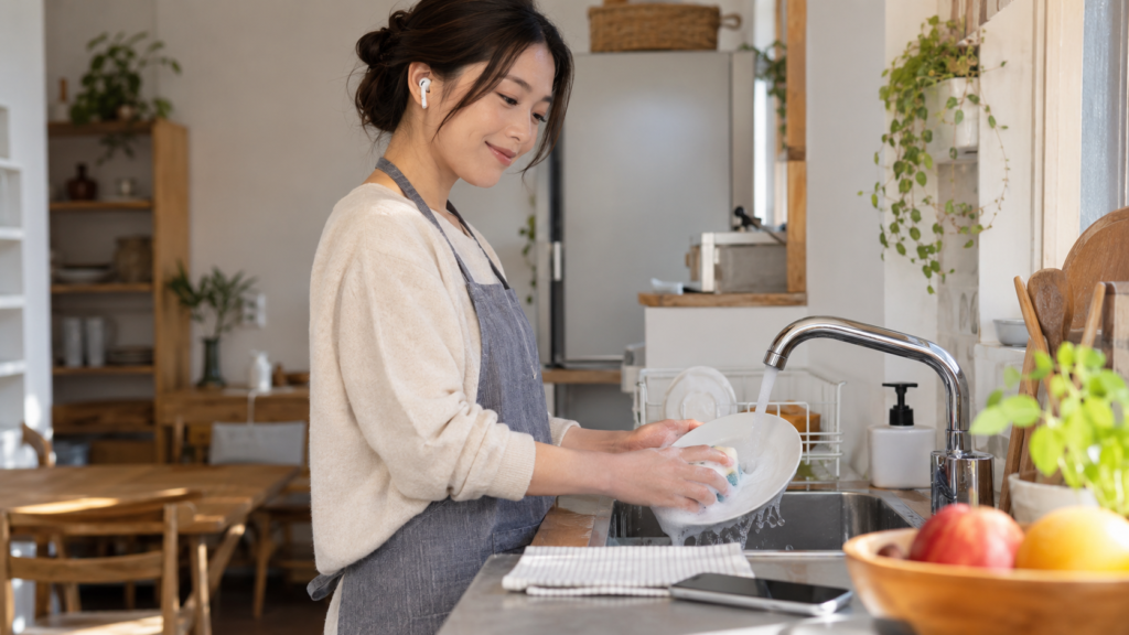 皿洗いをしながら音声読書を楽しむ日本人女性