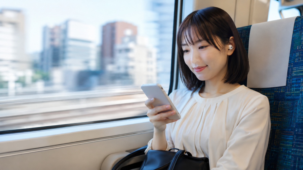 通勤電車でイヤホンを使い聞く読書を楽しむ日本人女性